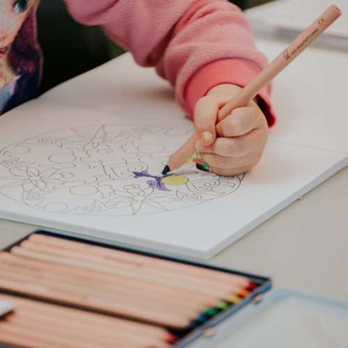 Pige tegner i en farvebog
