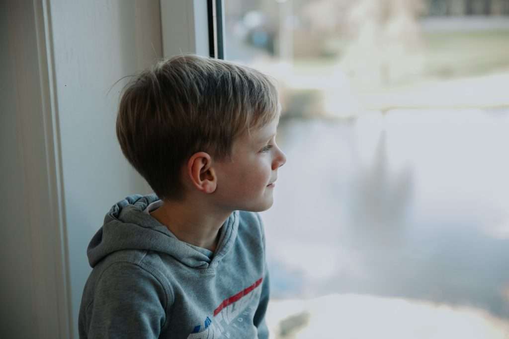 dreng kigger ud af vinduet